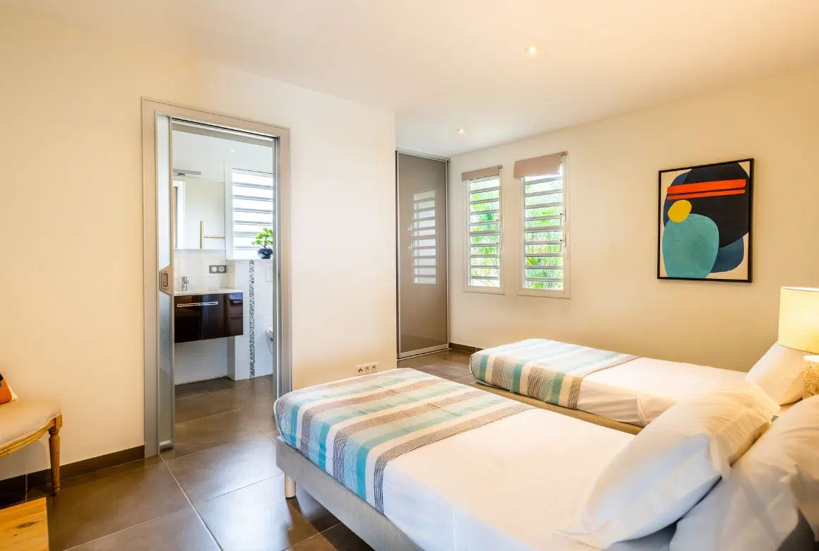 chambre avec 2 lits simples et salle de bain